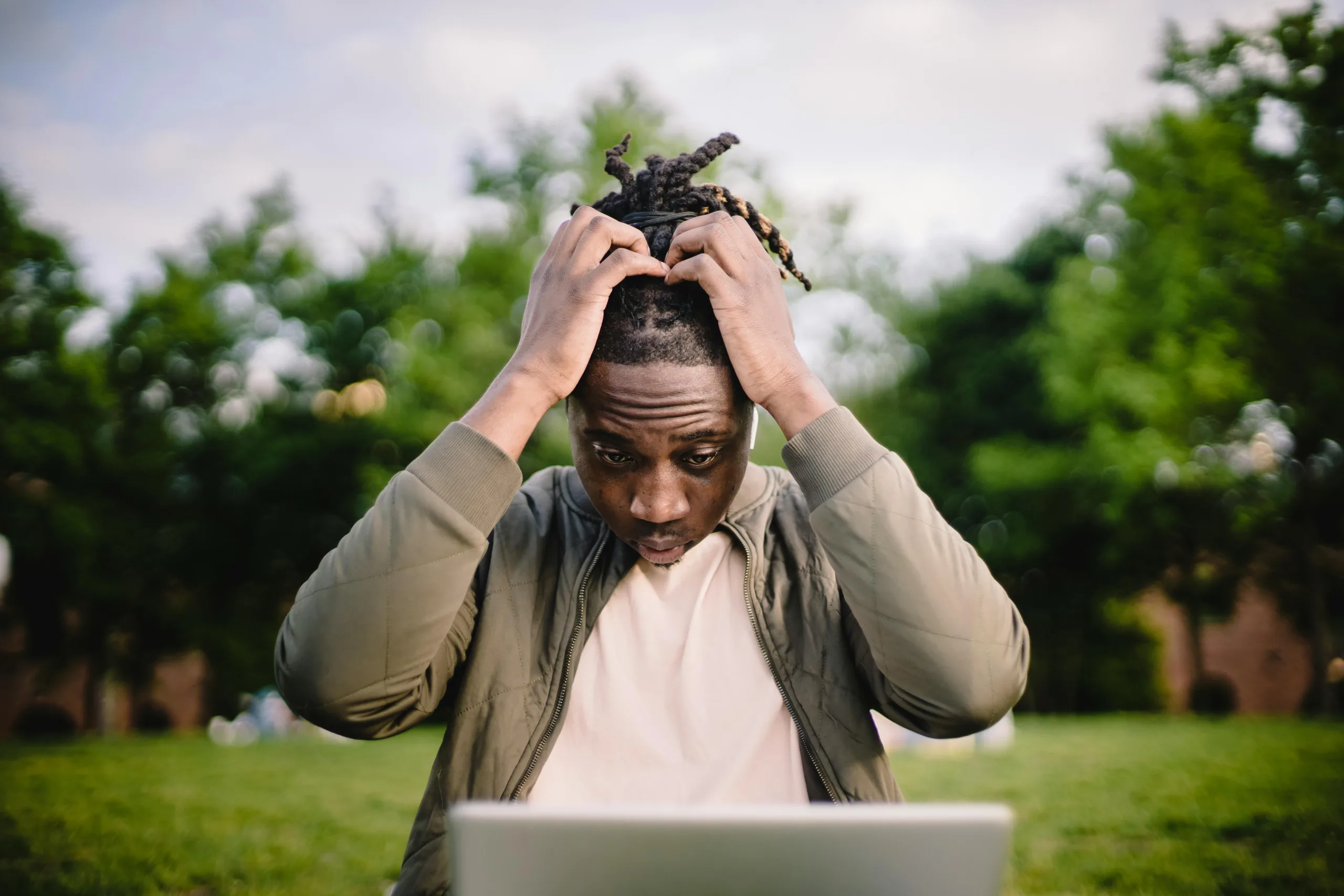 Decorative image to accompany blog post on common accounting mistakes: man in front of laptop holds his head in hands looking concerned.